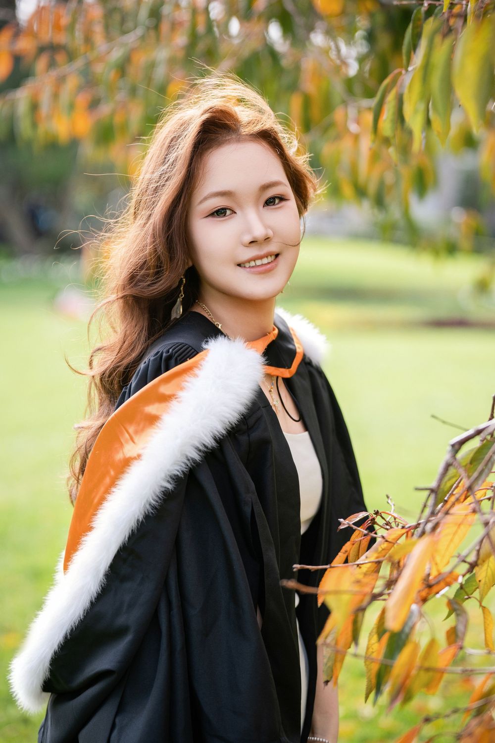 Fresh and natural lifestyle graduation photo of a female student on the green lawns of Albert Park.