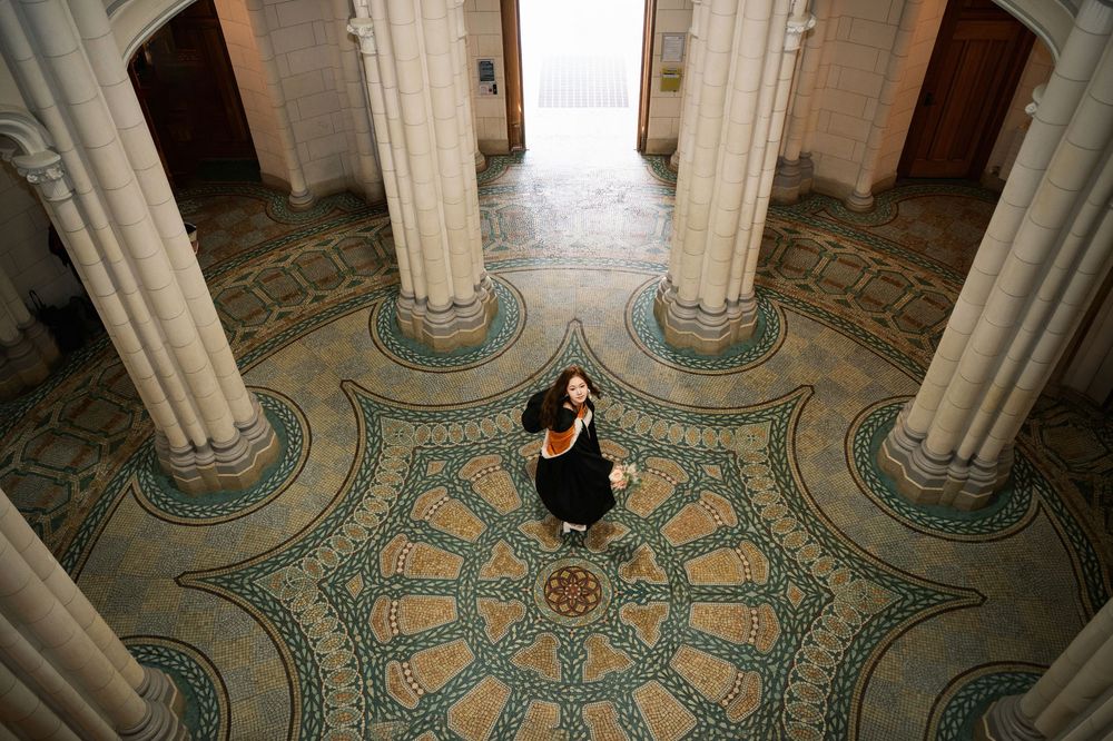 High-angle graduation photography inside the historic UoA Clock Tower, featuring the stunning mosaic floor.