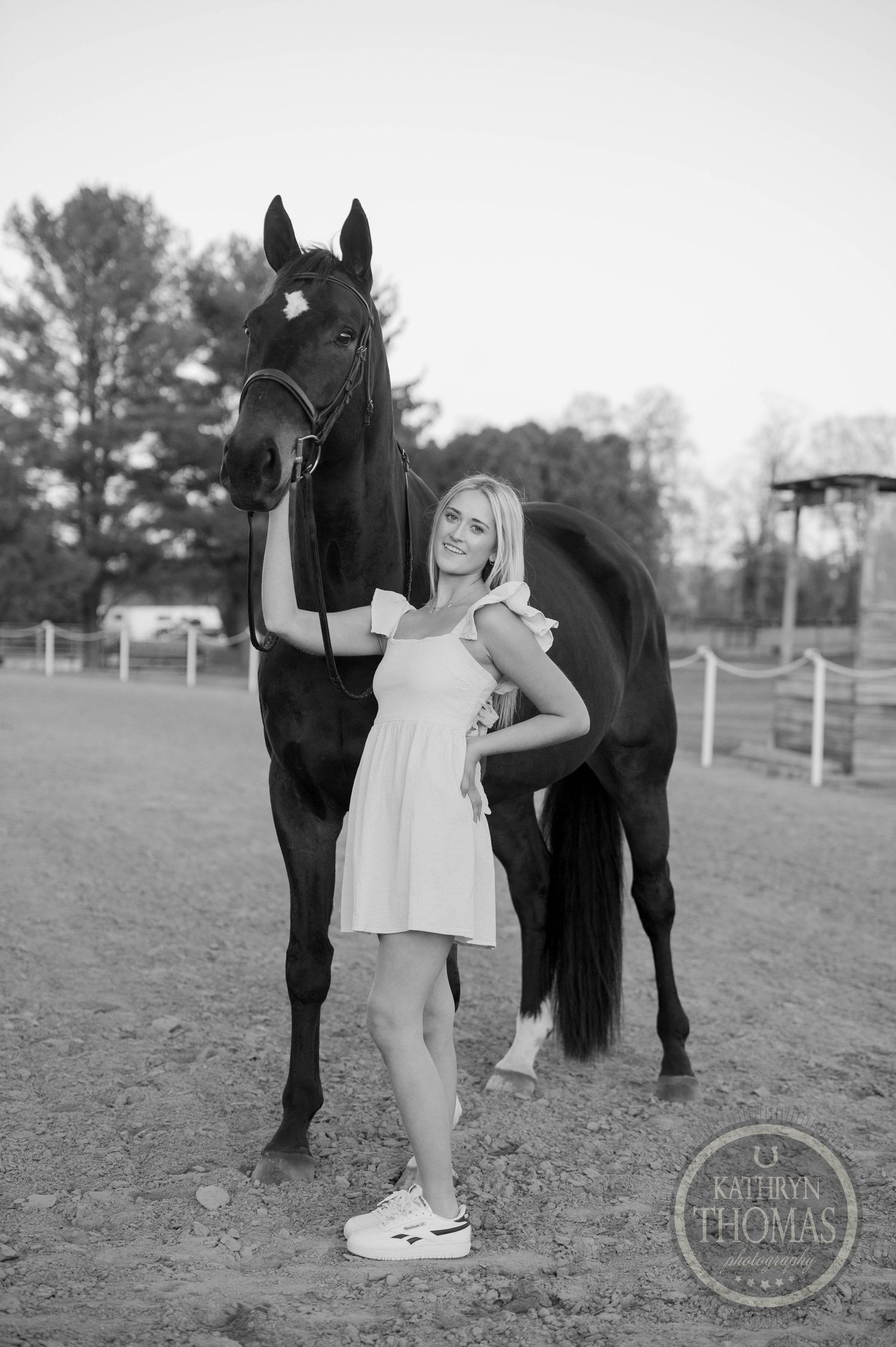 Black and white portrait of a person with a horse in an equestrian setting.