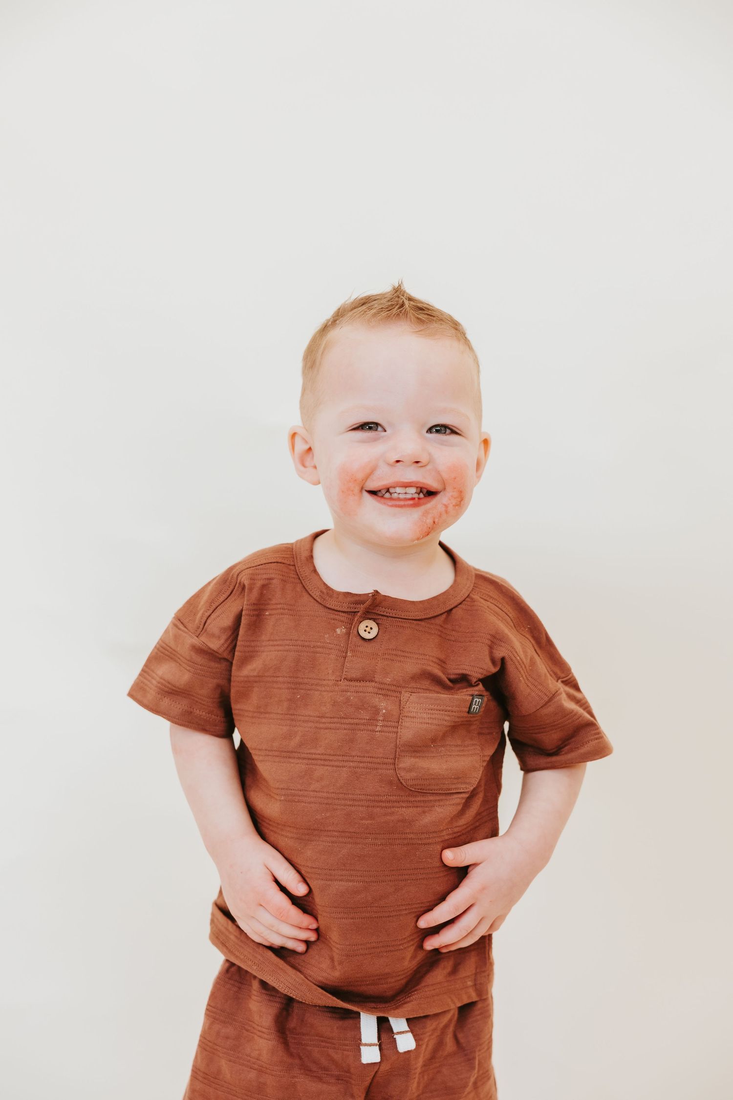 A happy moment captured against a simple white background wearing brown clothing.