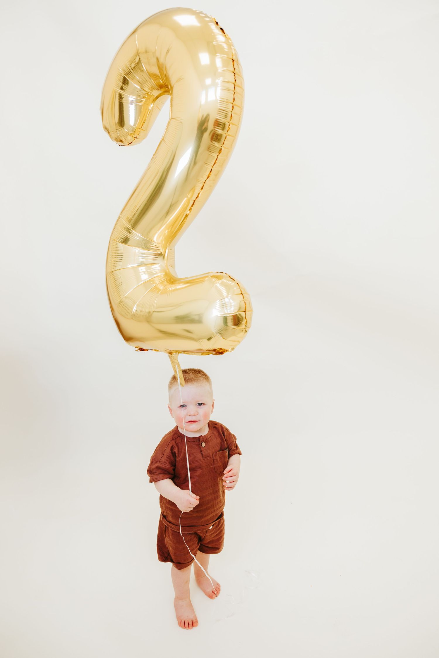 A celebratory photo with a large gold number 2 balloon overhead.