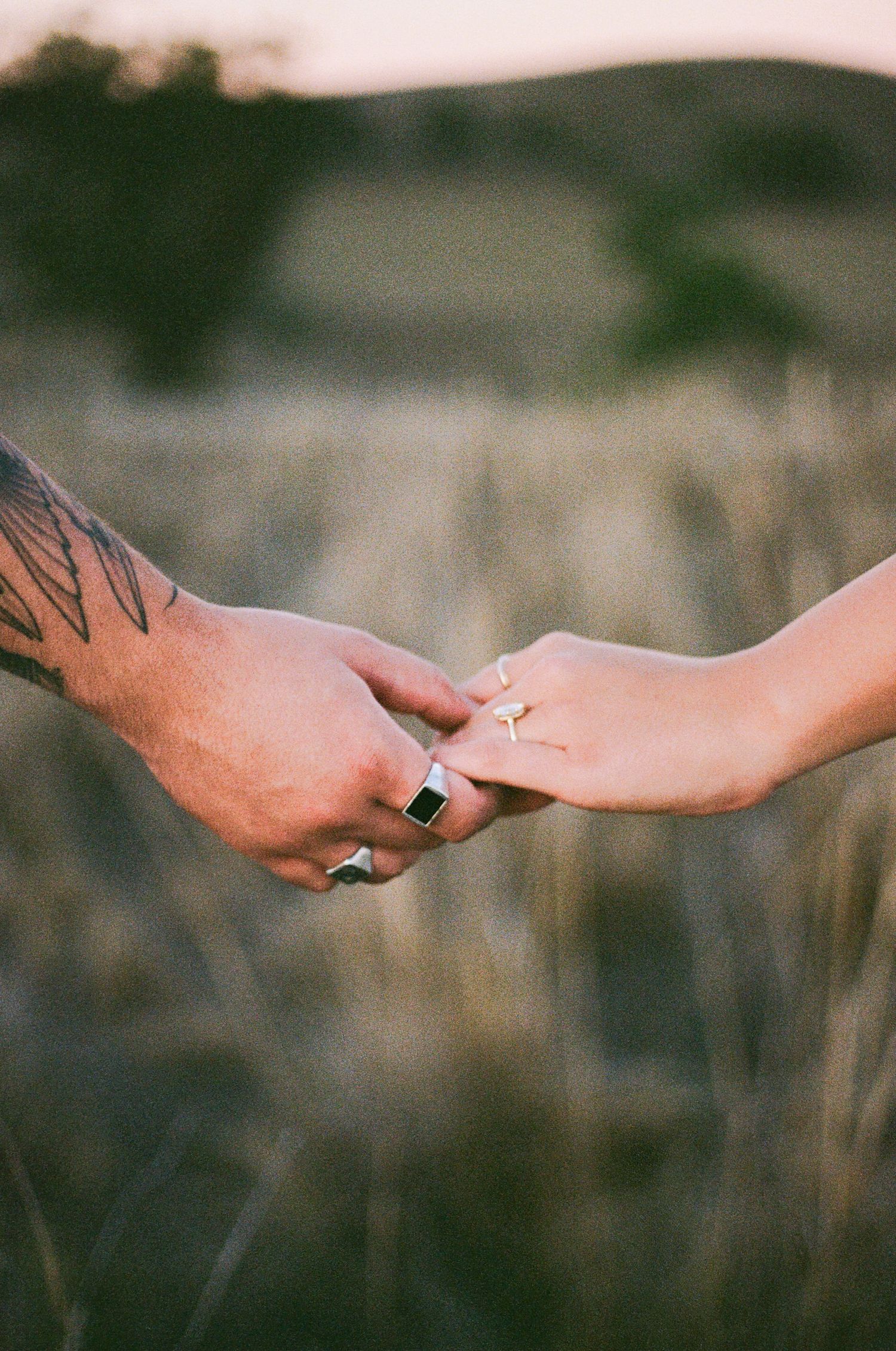 close up of rings and couple holding hands on film during engagement photoshoot at Scone NSW