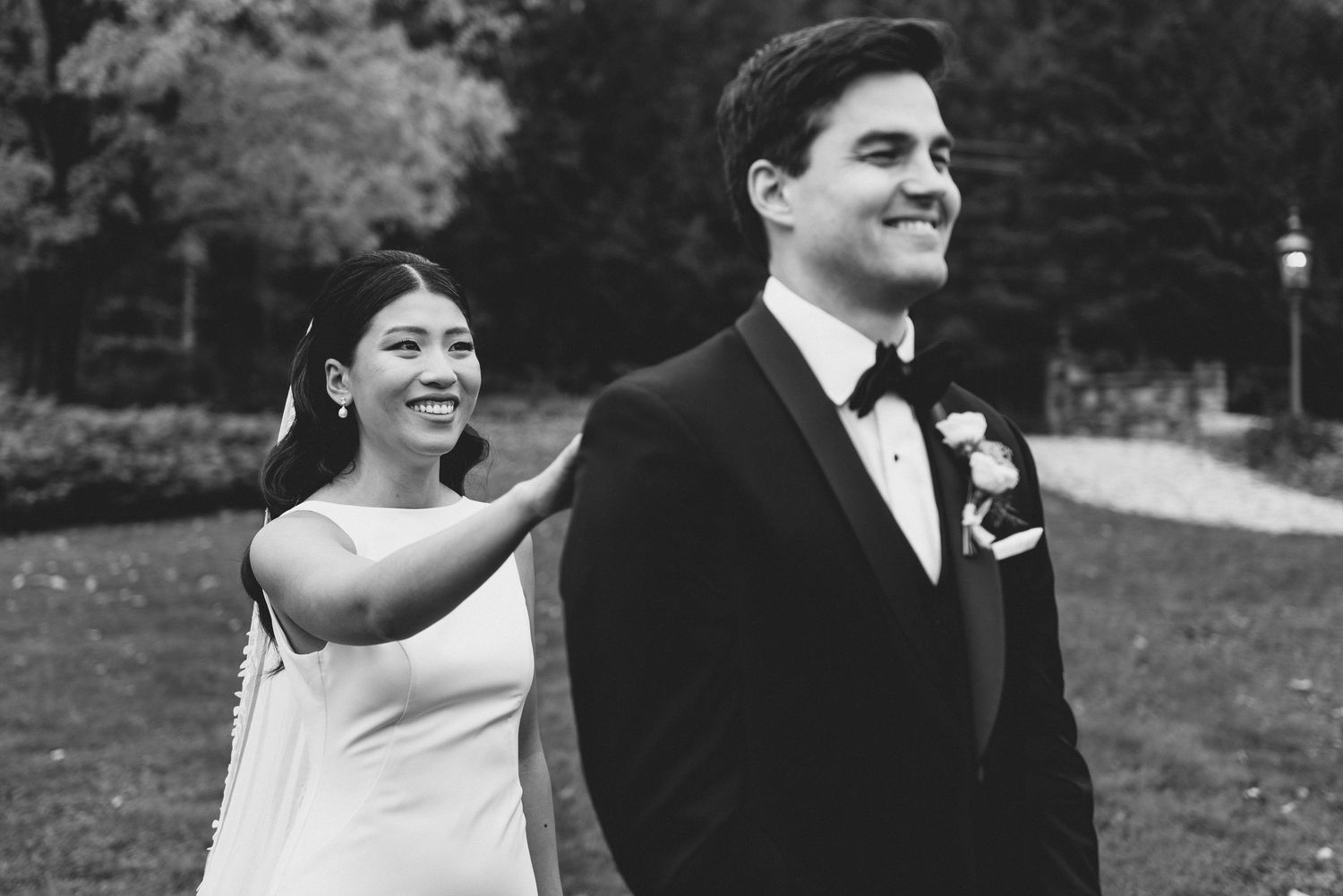 A happy couple shares candid laughter and joyful moments together in a black and white outdoor photo sequence.