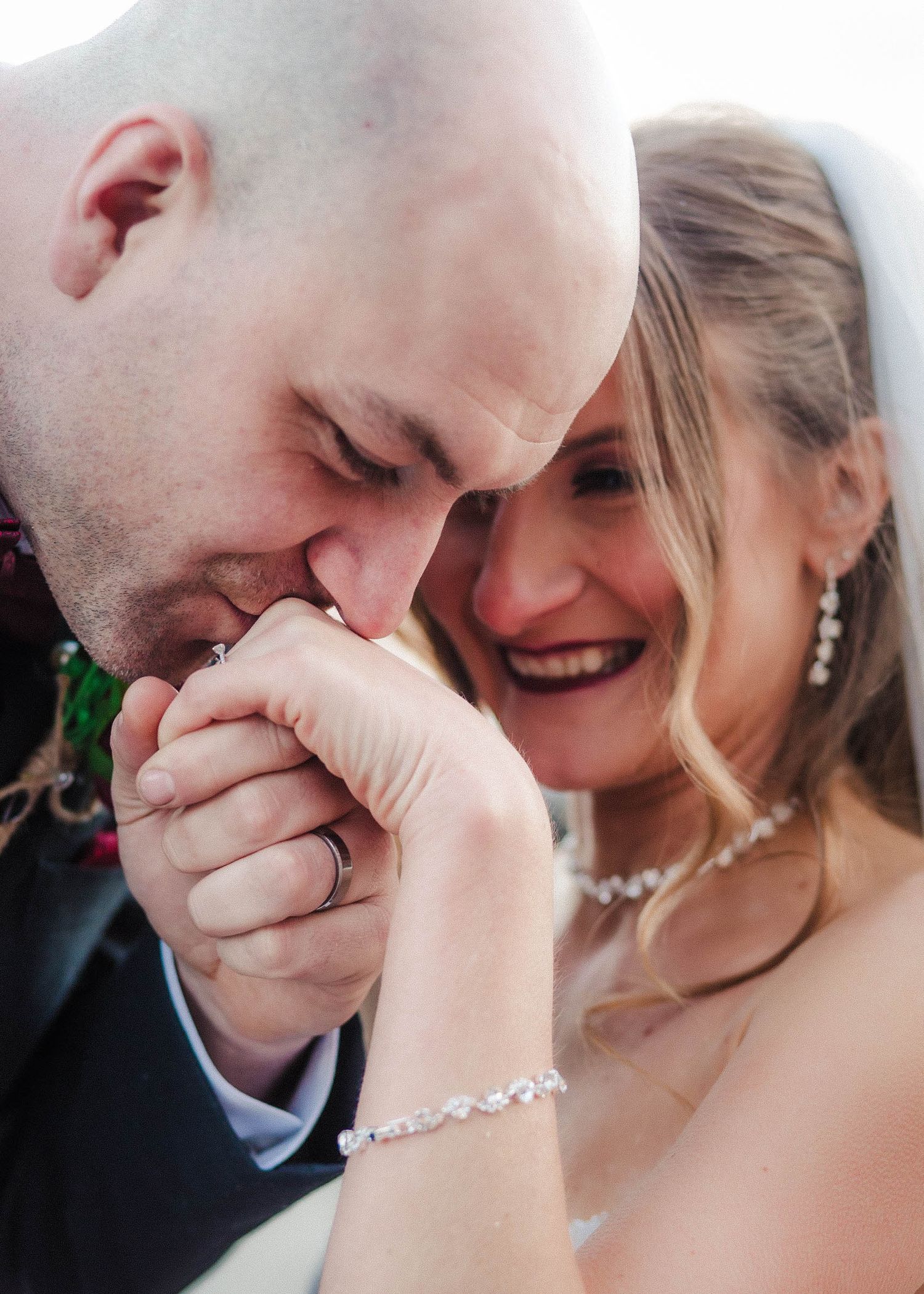 Romantic candid moment of couple in formal attire sharing an intimate gesture during their wedding celebration.