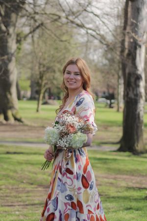 Portrait of a woman holding a bouquet of flowers.