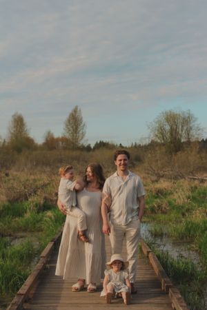Portrait of a young family including two toddlers with one on his mother's hip.