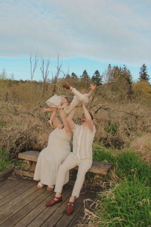 Candid photo of two parents holding their two toddlers in the air.