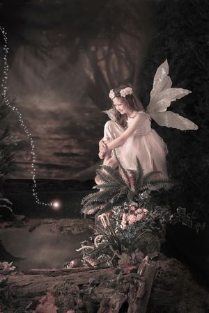 Dreamy fairy portrait in enchanted forest with mushrooms and magical sparkles.