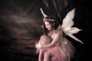 Ethereal fairy portrait with delicate wings in soft, dreamy lighting.