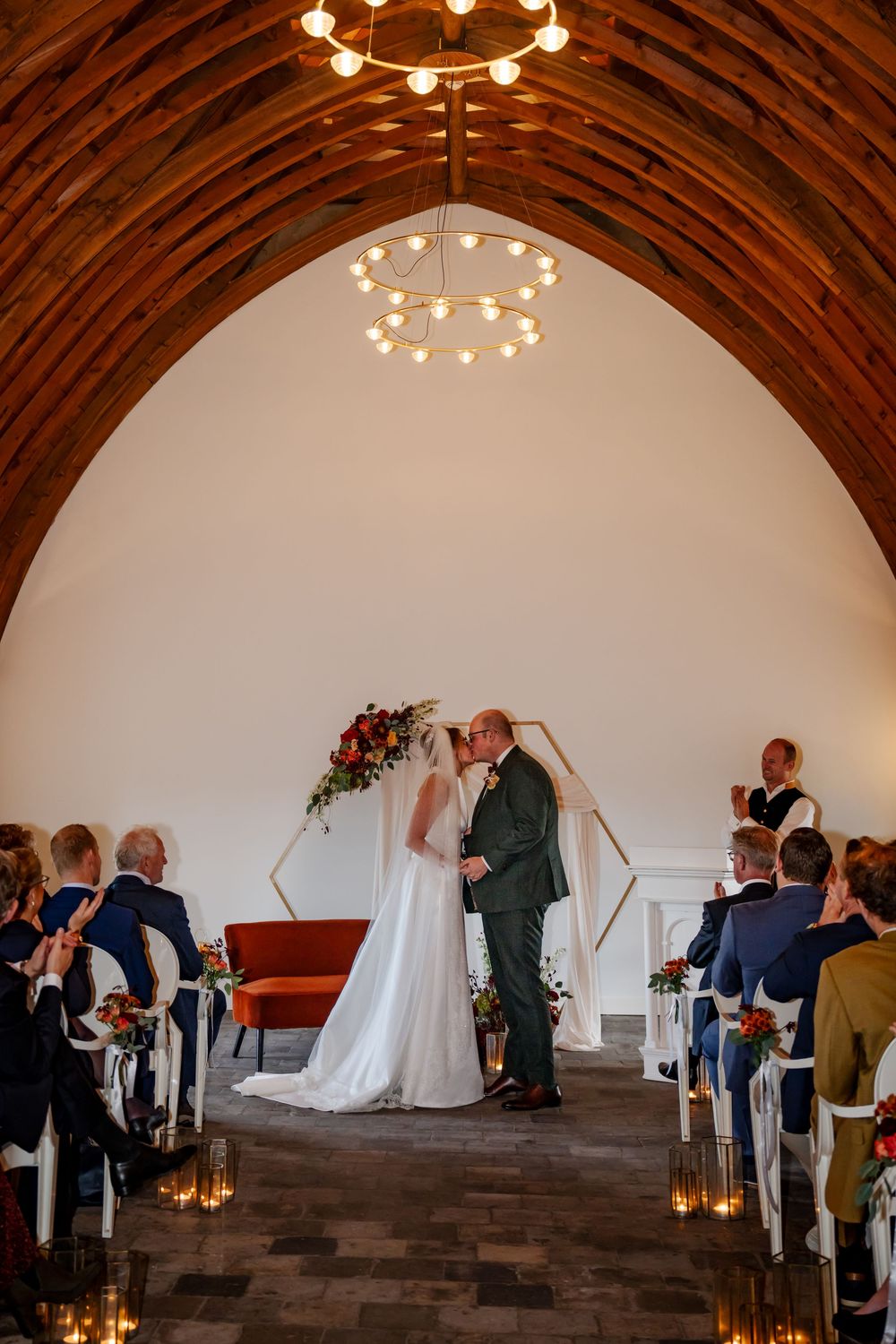 Trouwfoto van een bruidspaar die elkaar de kus geeft na het ja-woord tijdens hun trouwceremonie in de trouwlocatie Kasteel Woerden.