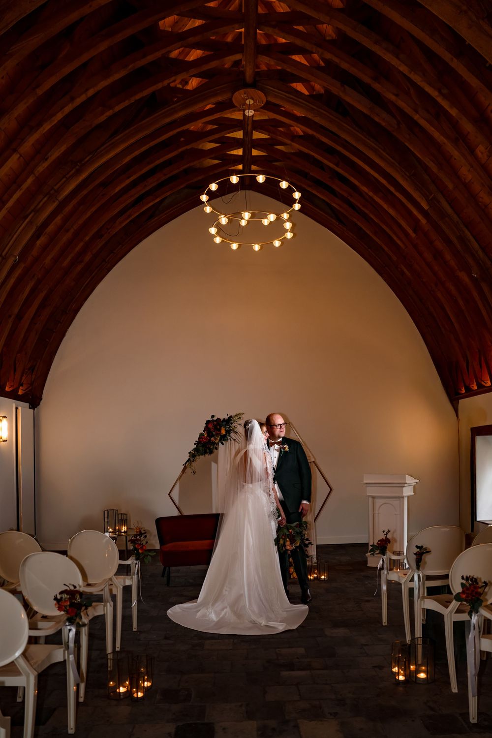 Bruid en bruidegom poseren voor hun trouwfoto in de trouwzaal van trouwlocatie kasteel Woerden.