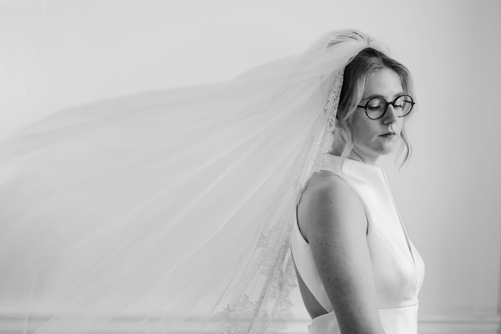 Zwartwit foto van bruid met waaiende sluier tijdens haar trouwreportage in trouwlocatie kasteel Woerden.