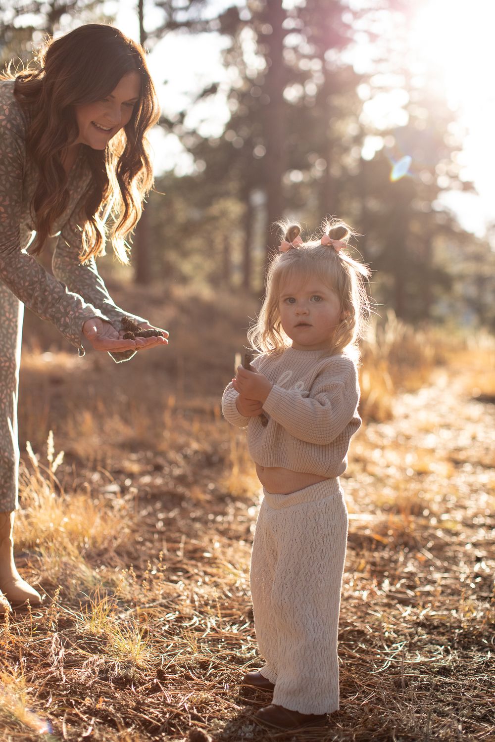 A sweet outdoor moment backlit by golden sunlight in a forest setting during sunset.