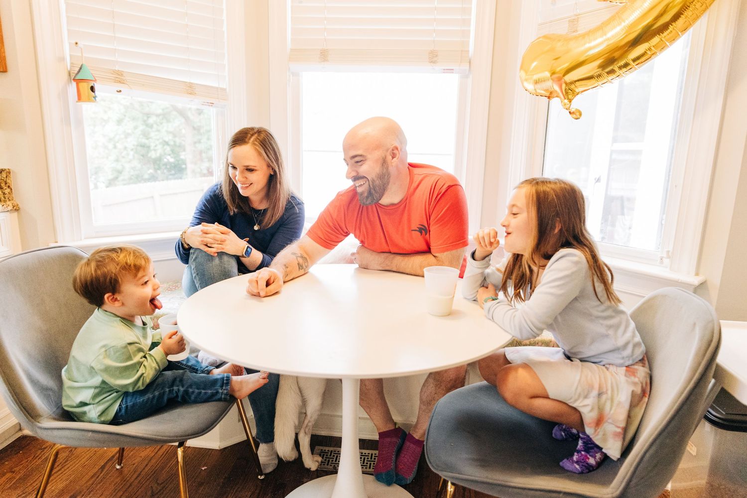 Family enjoying a relaxed moment together at a bright dining table in their home.