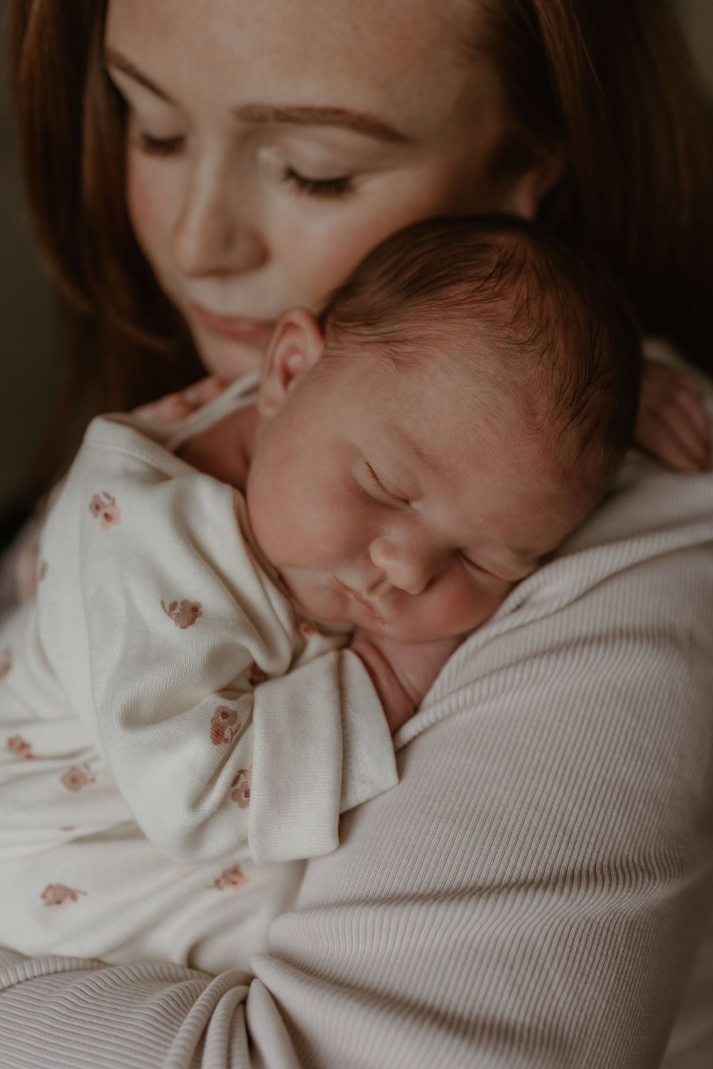 Sleeping newborn rests peacefully on her mum.