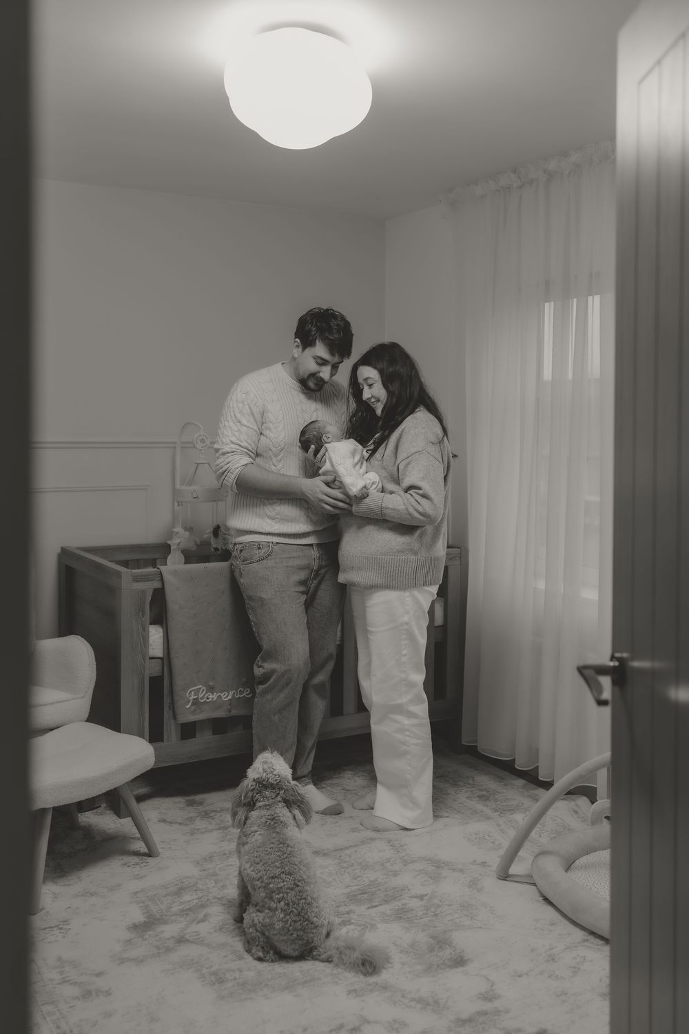 A family shares intimate moments with their newborn baby and dog, embracing their new family life.