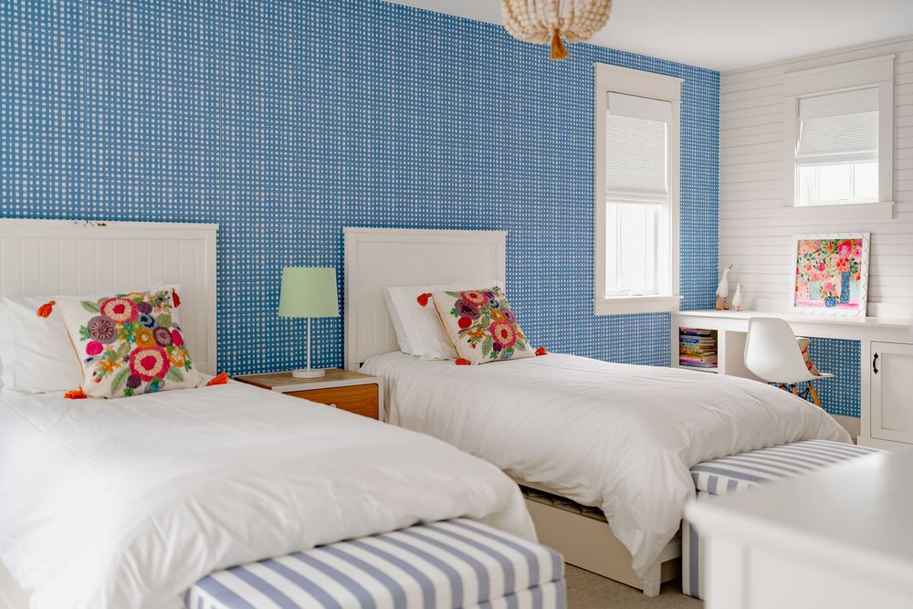 Modern coastal bedroom features blue grasscloth wallpaper, white bedding, and woven pendant light fixture.