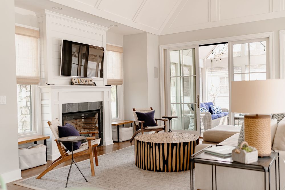 Bright open concept living space with white walls, hardwood floors and natural light streaming through windows.