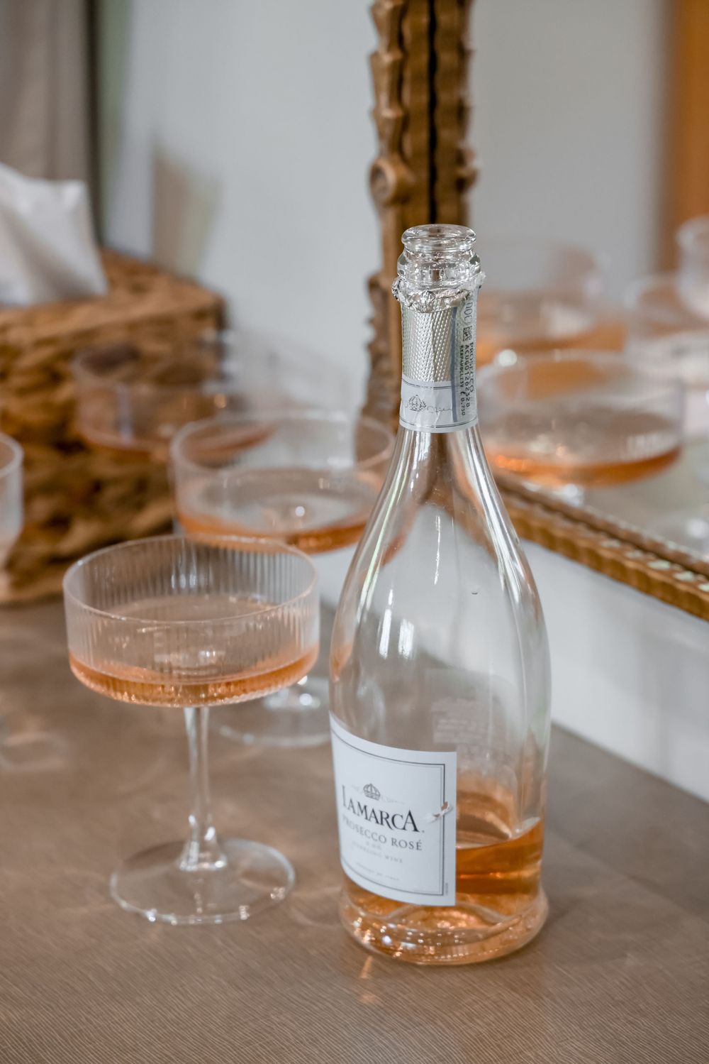 Close-up of glass bottles and cocktail glasses arranged on wooden table at reception.