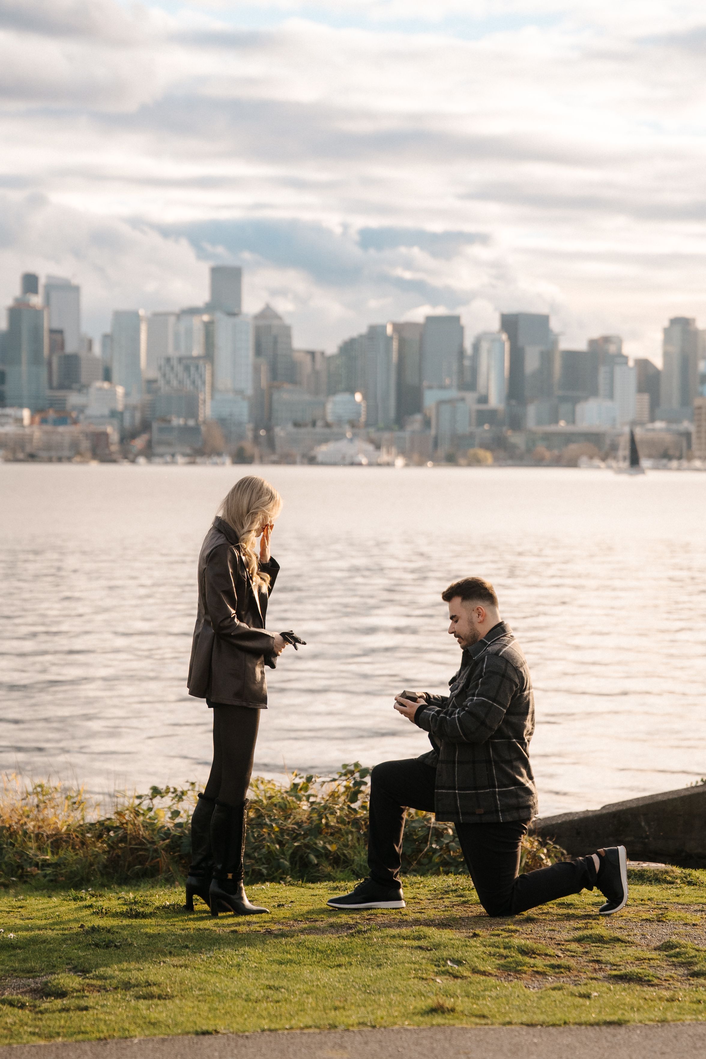 A romantic proposal sequence captured at sunset along the Vancouver waterfront with the city skyline in the background.