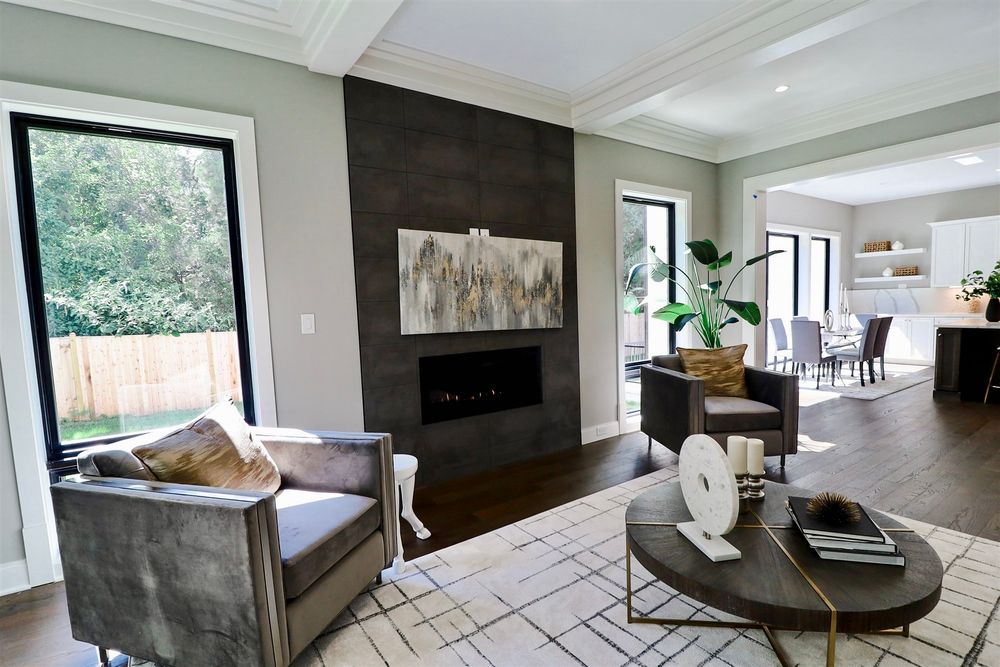 Contemporary open floor plan living space with fireplace and large windows letting in natural light.