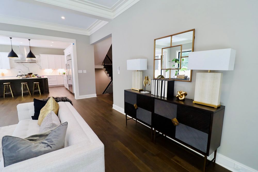 Contemporary living space featuring clean lines, dark wood floors and white walls with black accent lighting.