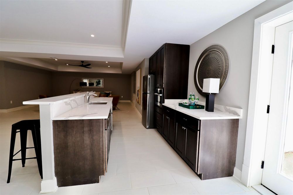 Sleek modern kitchen with dark cabinets, stainless steel appliances and minimalist design elements.