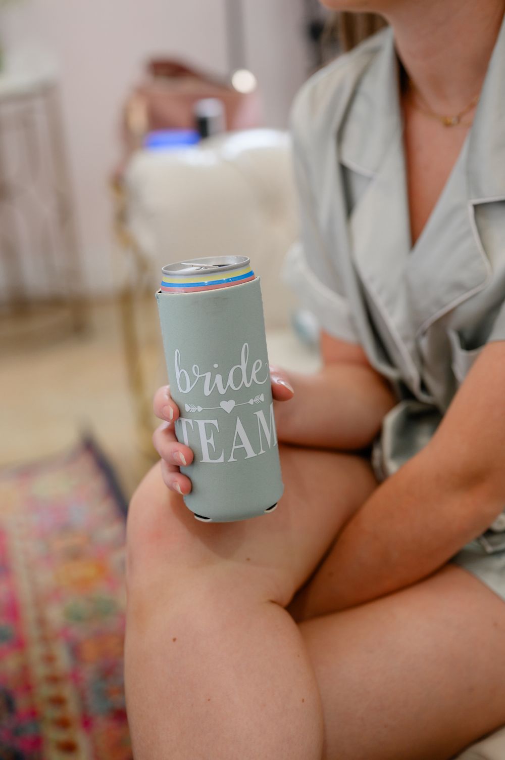 Mint green wedding koozies with custom text displayed on a table.