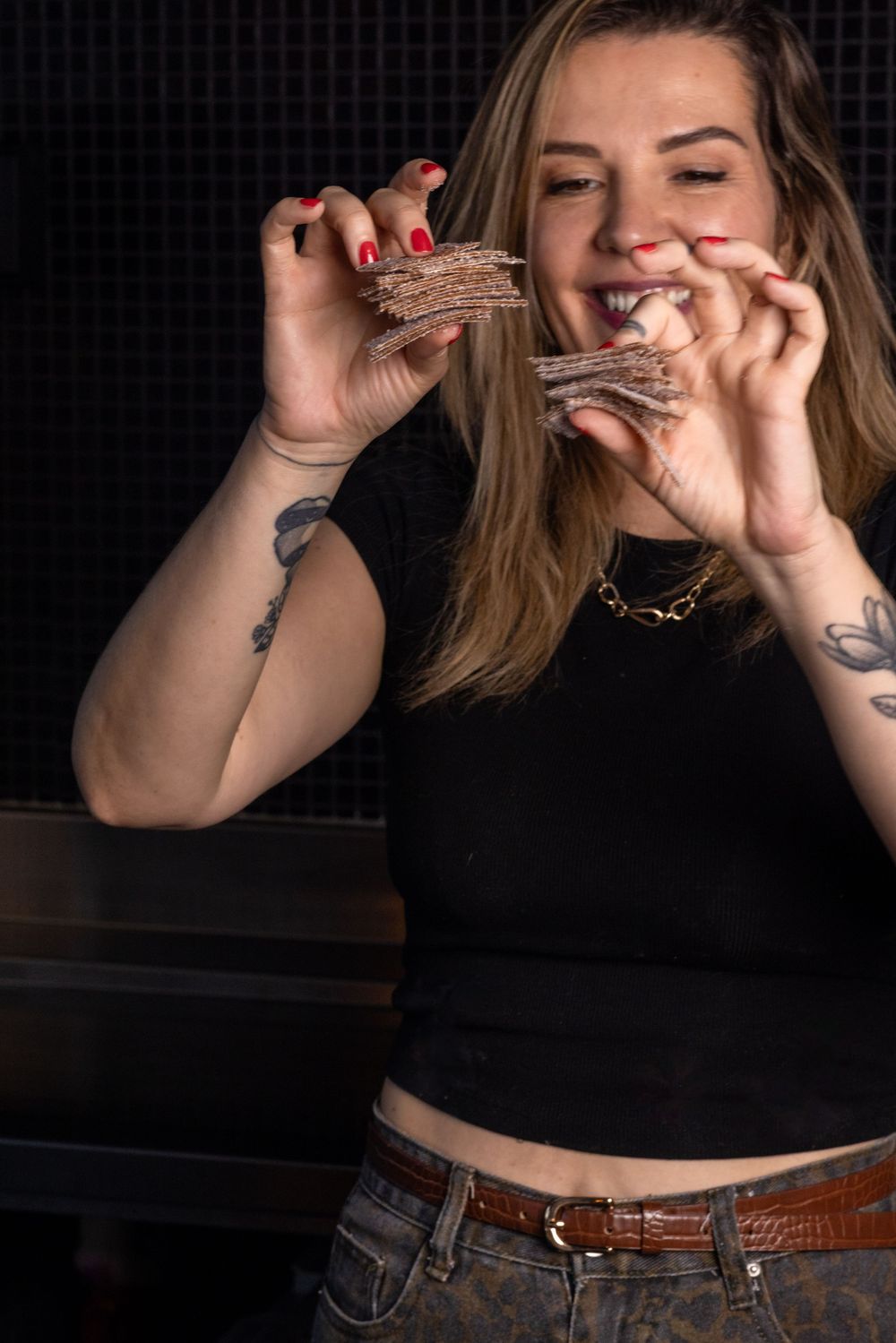 A series of cropped photos showing someone in a black top and jeans making playful hand gestures against a dark background.