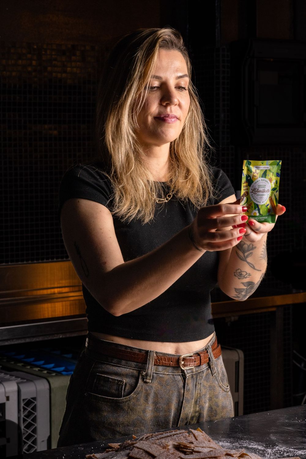 A person in a black shirt holds a beverage against a dark background in a sequence of artistic photos.