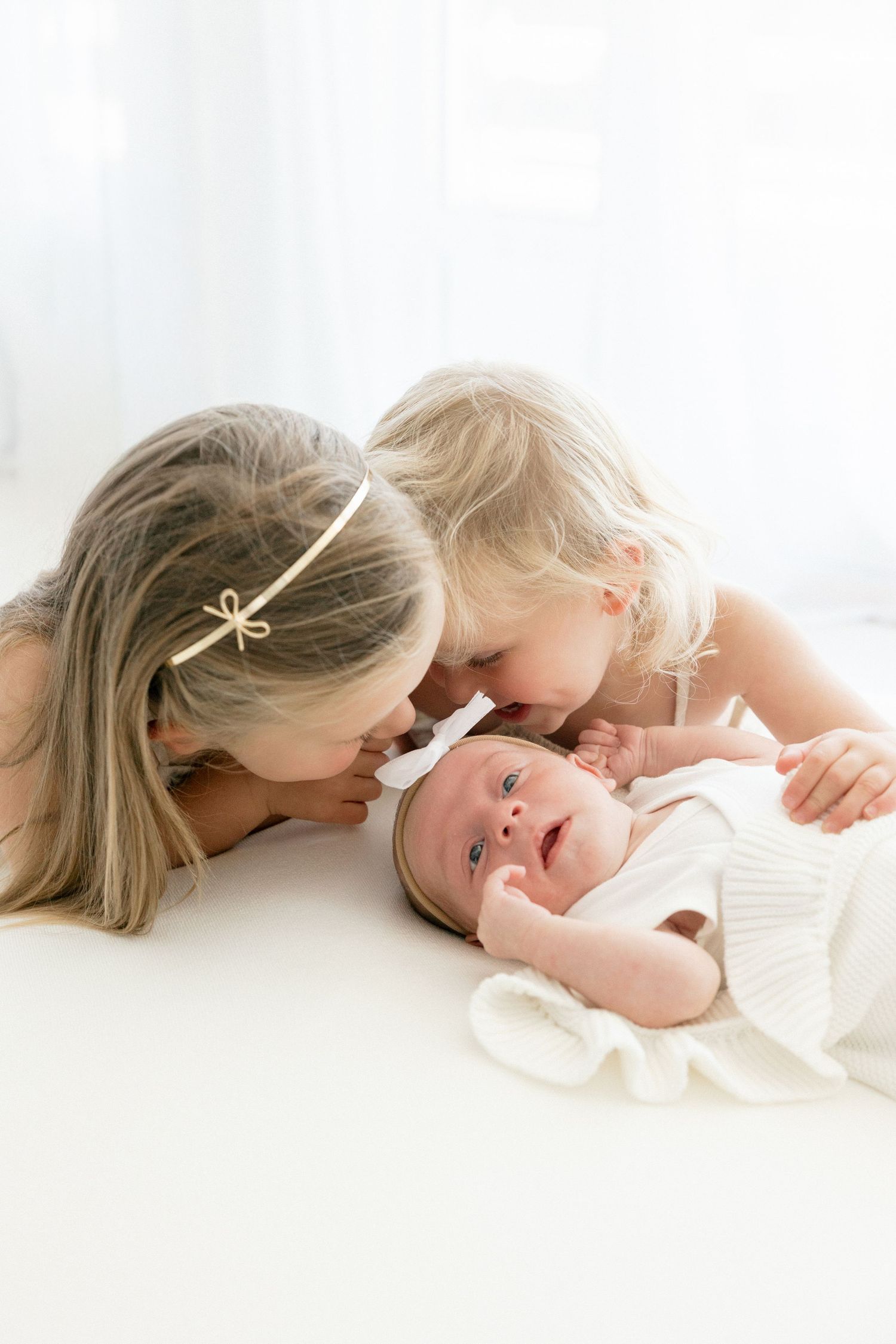 A series of intimate family photos showing tender moments between parents and children on a couch in soft, warm lighting.
