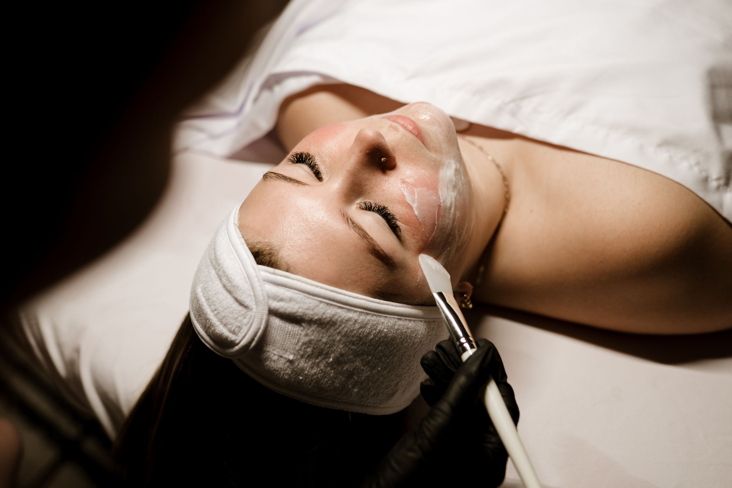 A person lies peacefully on white bedding in a series of close-up shots showing relaxed facial features.