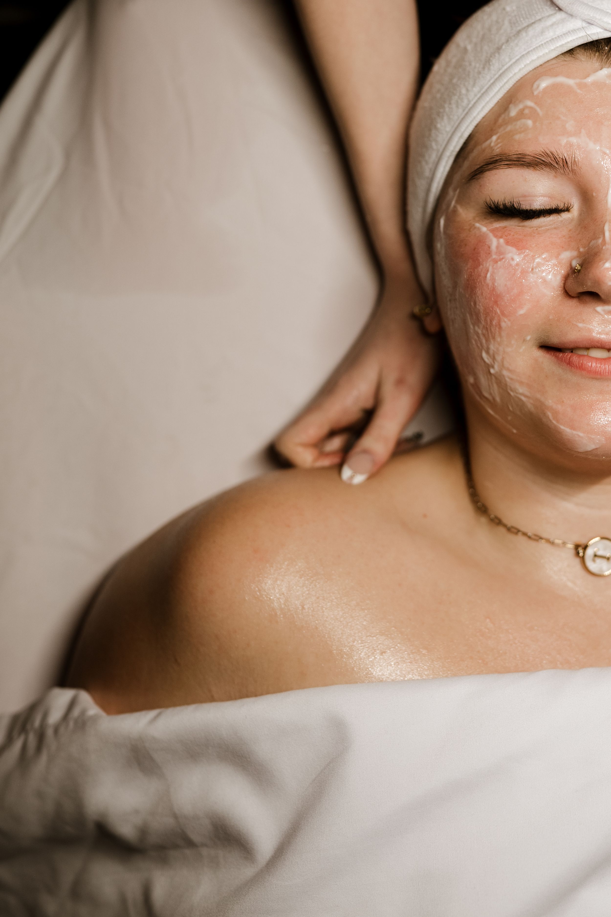A series of spa facial treatment images showing white clay mask application and relaxation on clean white sheets.