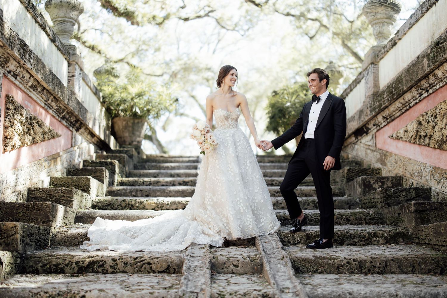 An elegant winter wedding reception features romantic white floral decor and candlelight in a grand venue setting.