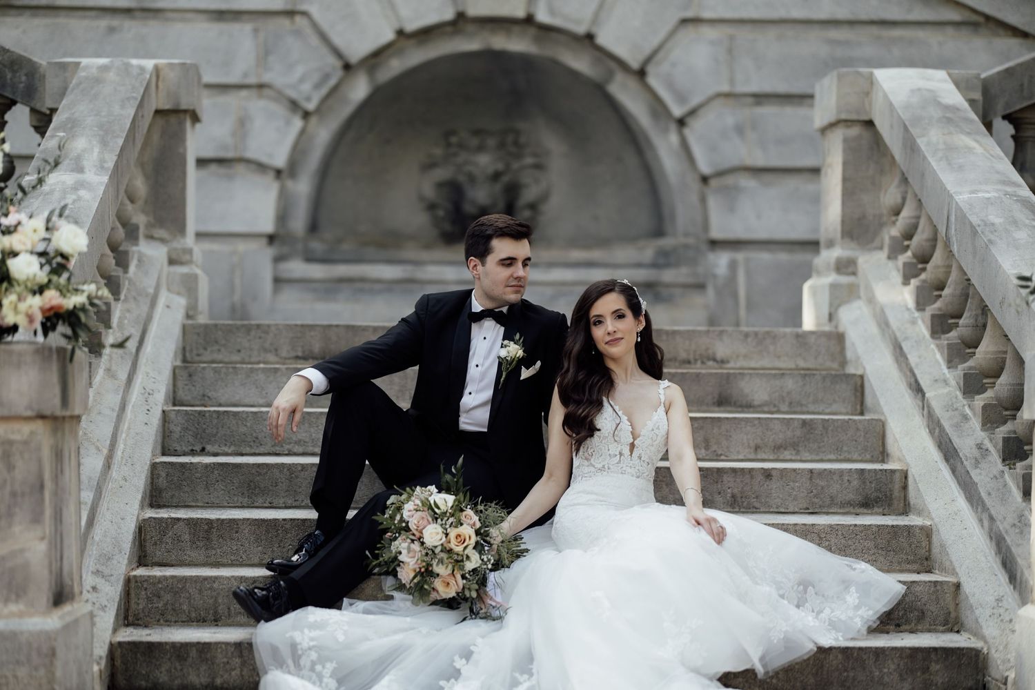 An elegant winter wedding reception features romantic white floral decor and candlelight in a grand venue setting.