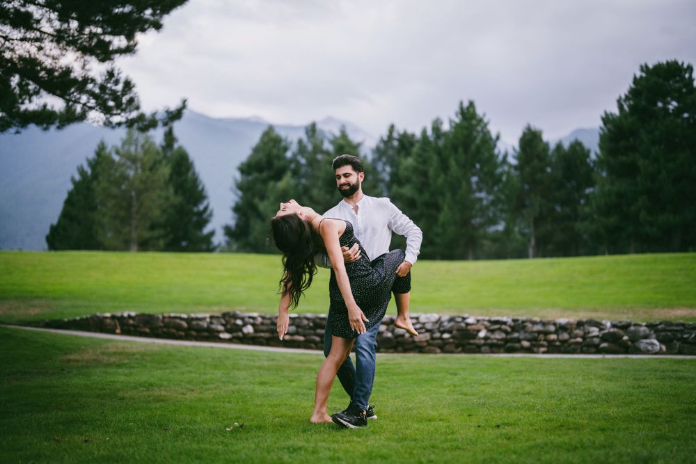 Couple performing a romantic dance lift on a scenic golf course.
