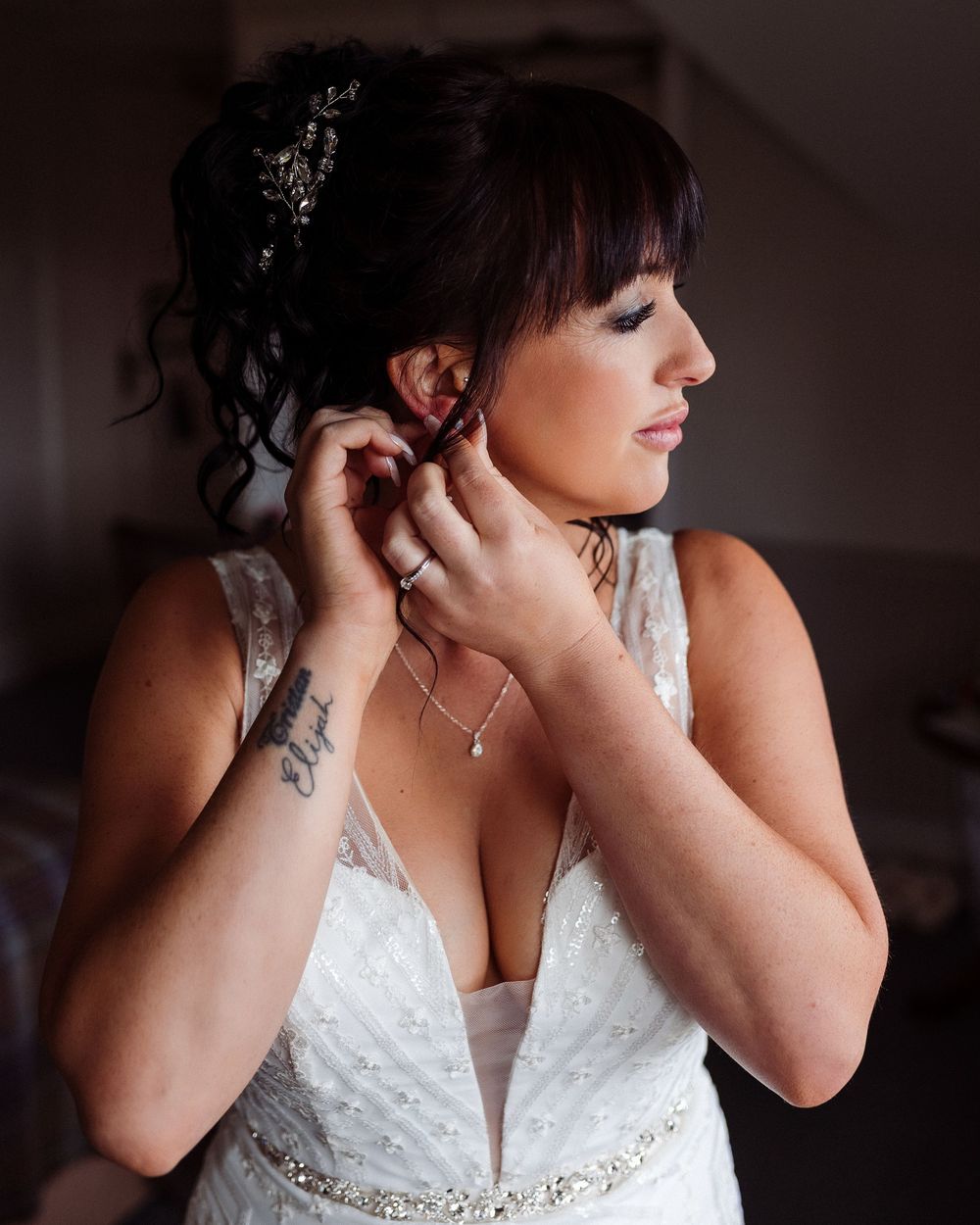 Close-up detail shots of a bride getting ready in a white beaded wedding gown with silver embellishments.