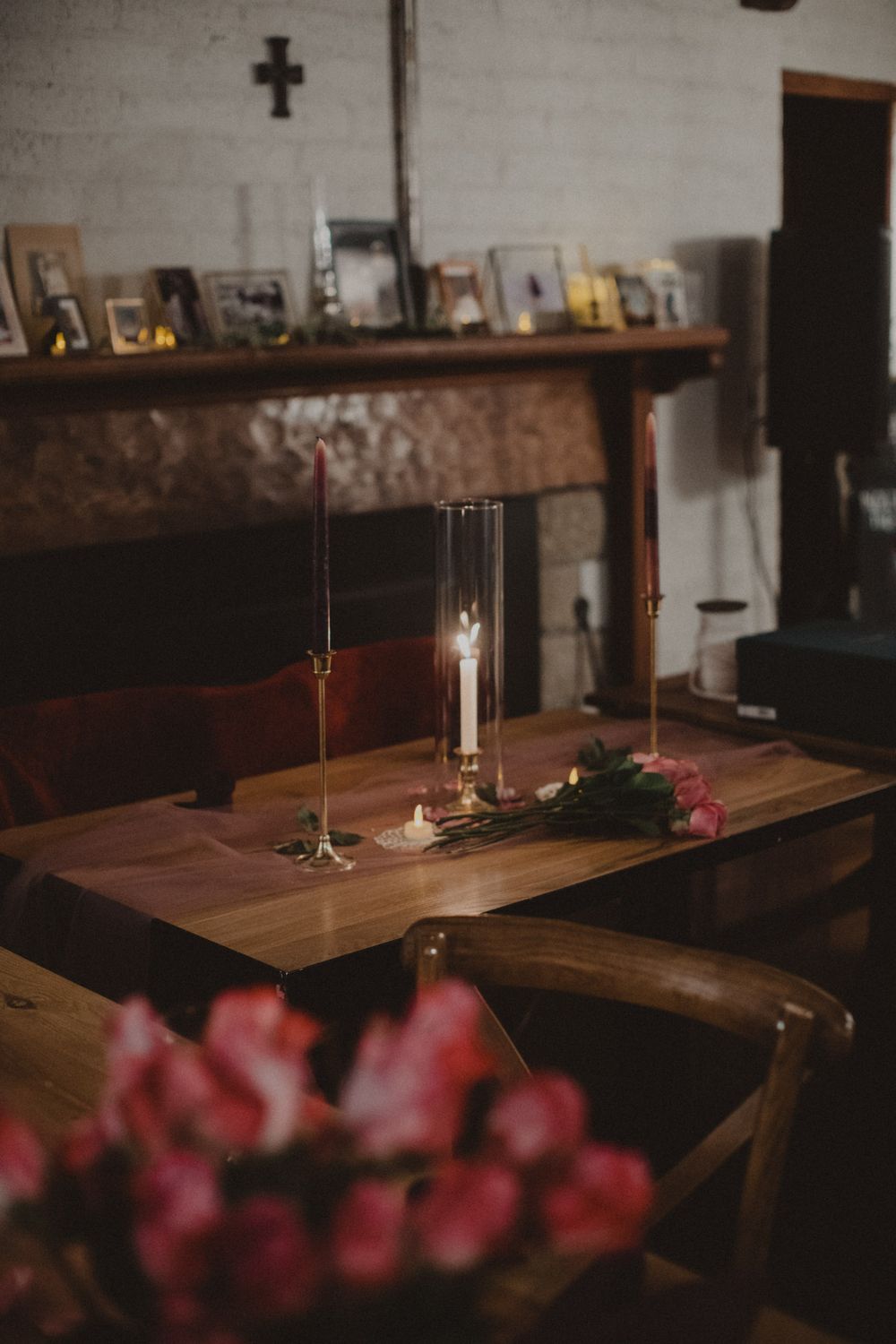 Rustic wooden tables in a dimly lit restaurant with pink cherry blossoms in the foreground.