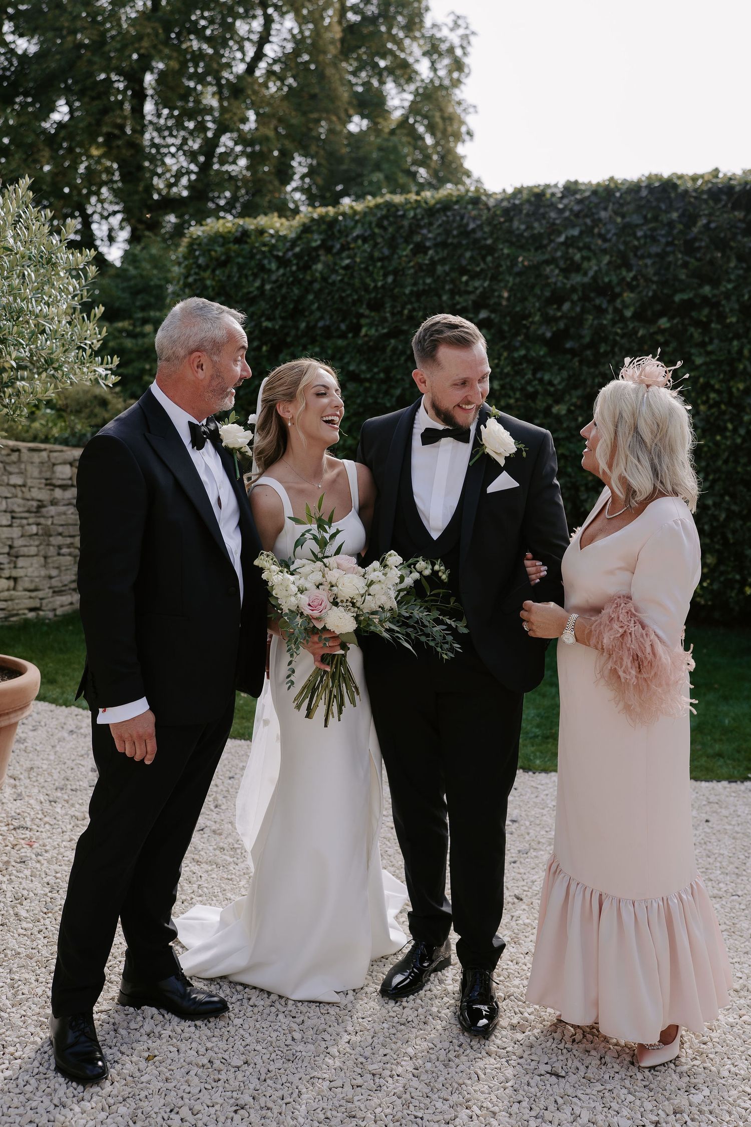 bride and groom laughing with brides parents at ivy lodge in cirencester