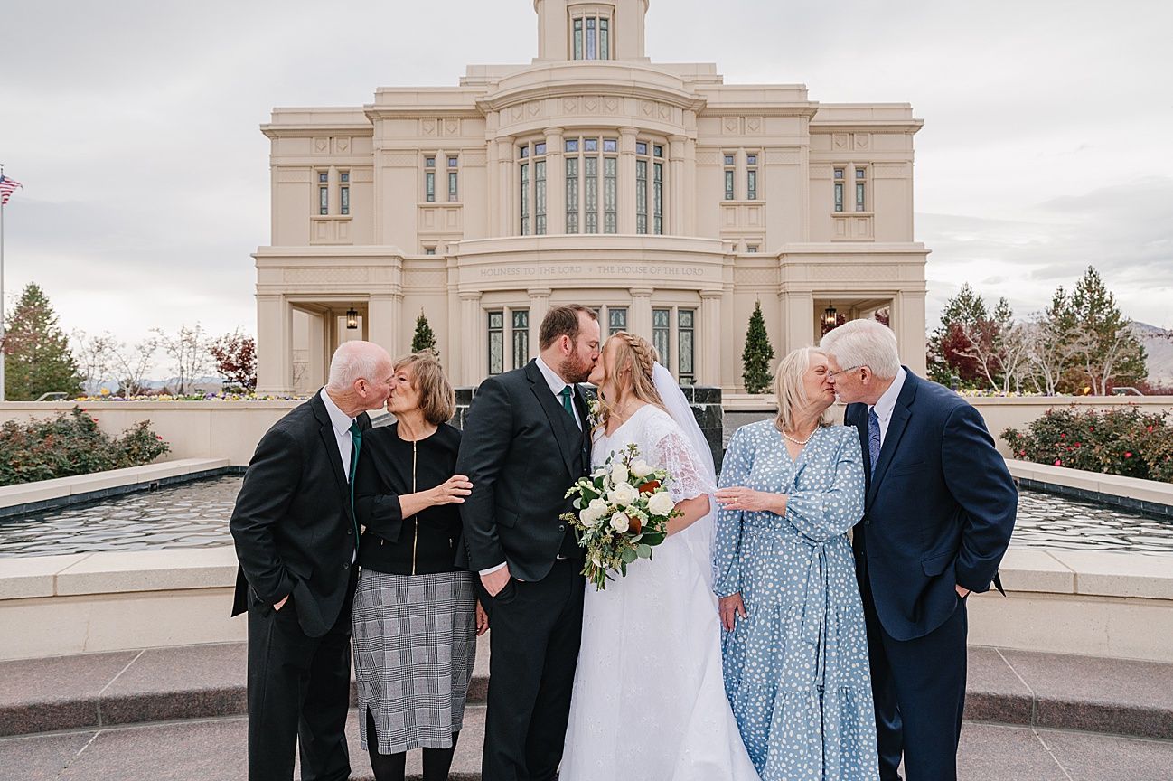 A group gathers outside a white historic temple building during a formal celebration event.