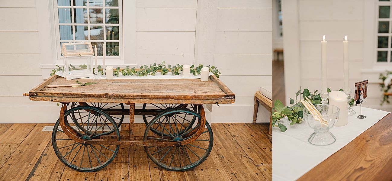 A rustic wooden cart decorated with greenery and candles inside an elegant white interior space.