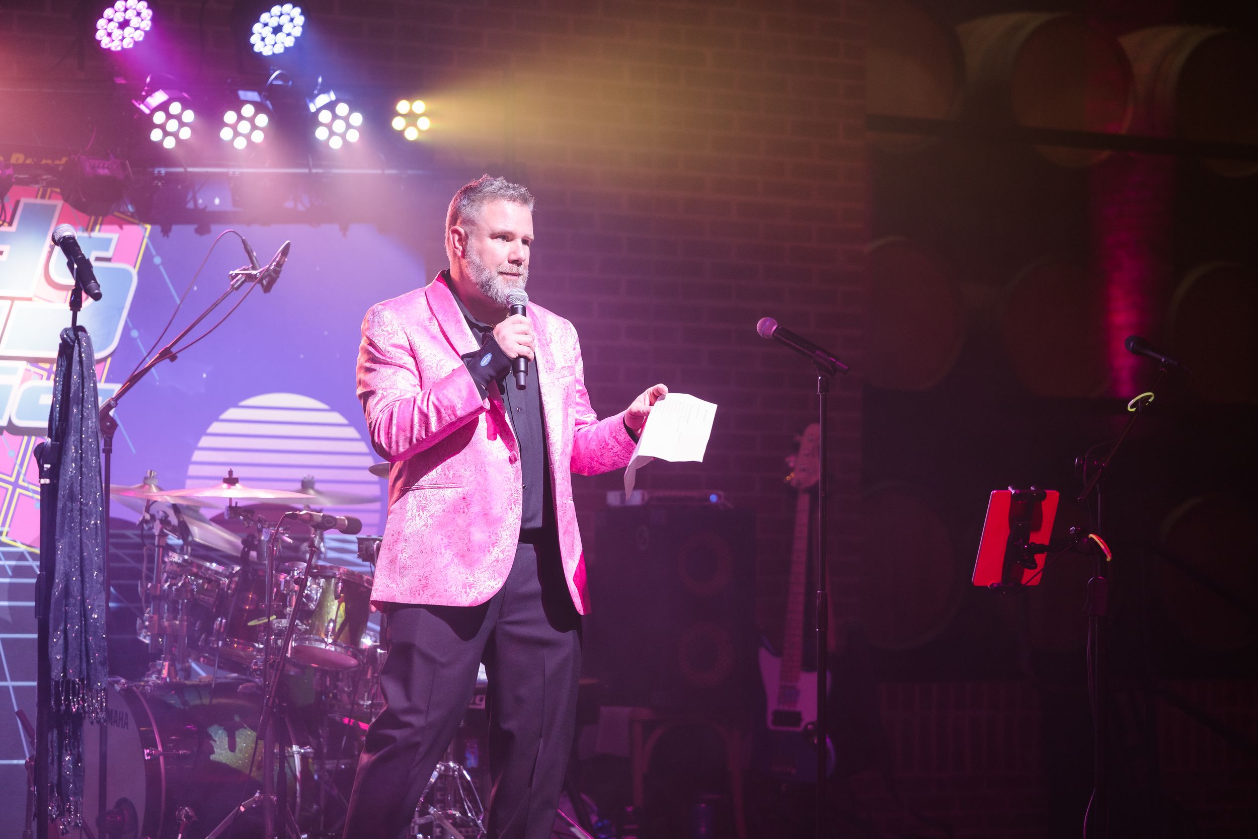 Concert or performance venue with purple stage lighting and sound equipment.