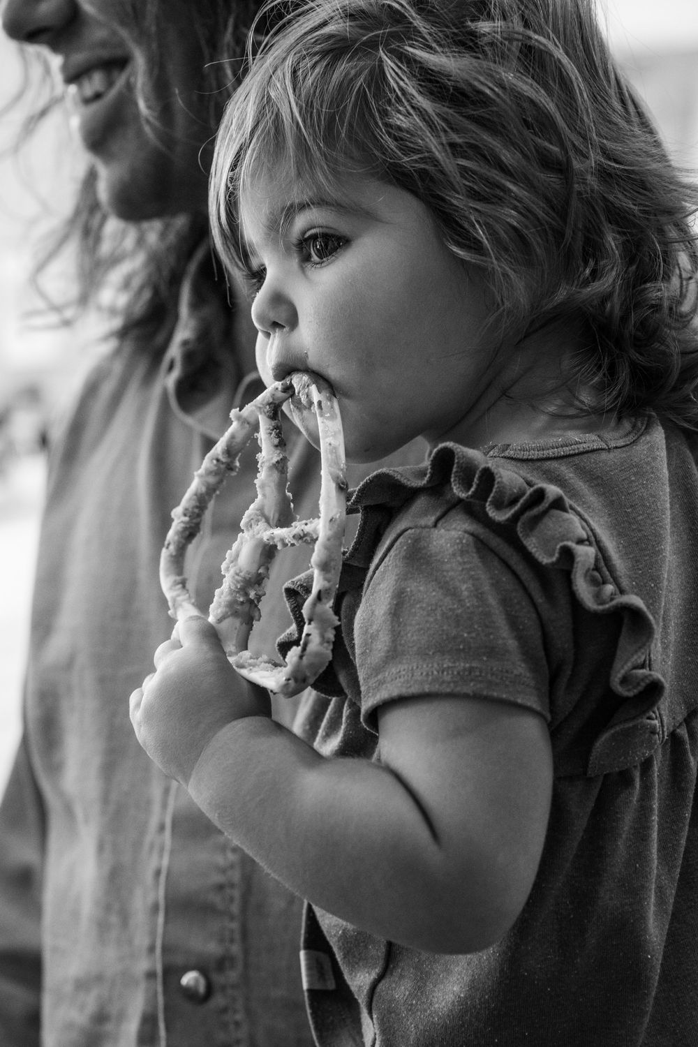 Black and white sequence of a young child eating a snack with messy hands and face.
