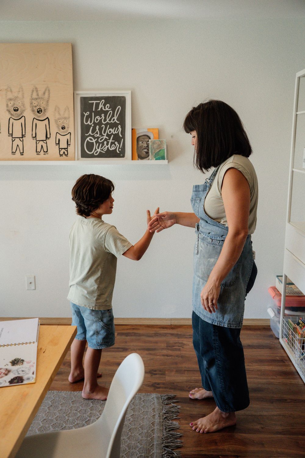 A sequence of photos showing a person drawing on a wall-mounted whiteboard in a room with hardwood floors.