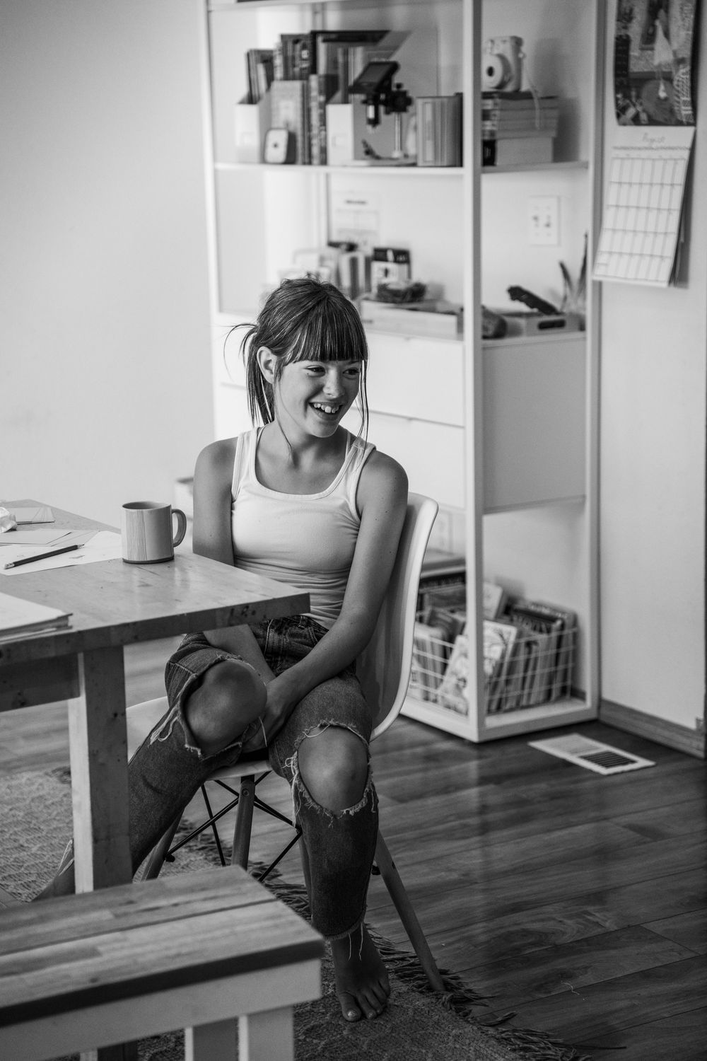 Black and white photo series showing a person in casual attire sitting at a desk in a minimalist interior space.