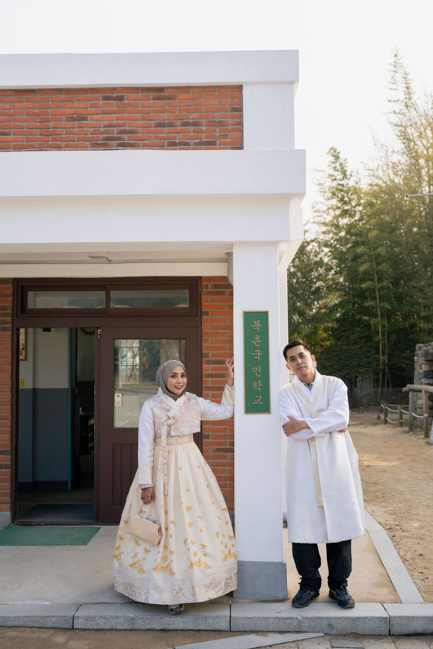 A series of photos showing people in traditional Korean hanbok dress and white attire standing outside a brick building.