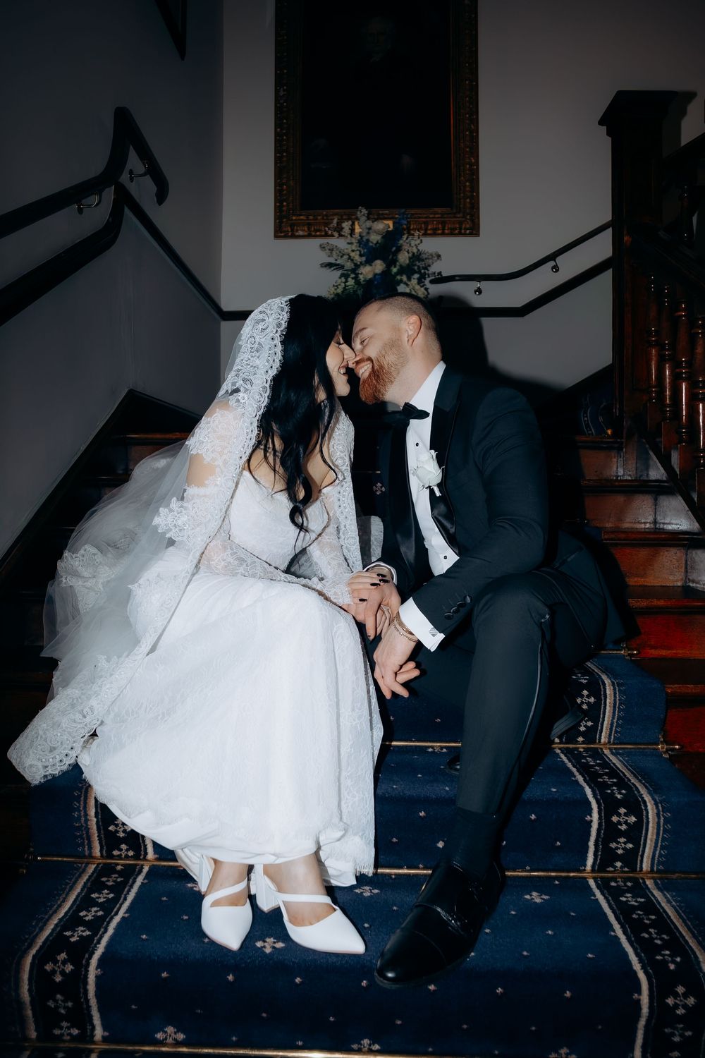 A sequence of romantic dance dips between a bride in white dress and groom in black suit on a blue carpeted floor.