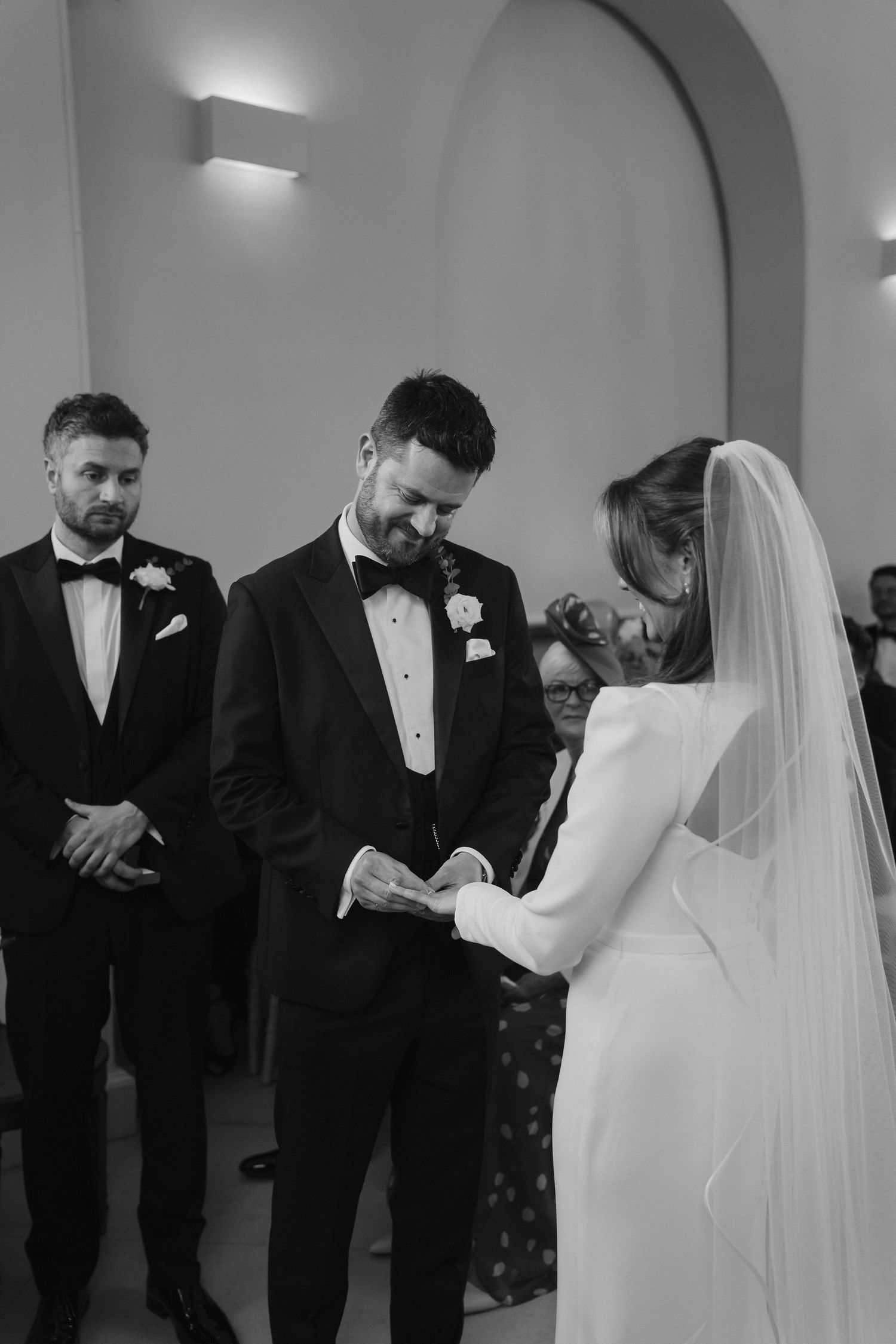 groom placing the ring on the brides finger during exchanging of rings at Iscoyd park