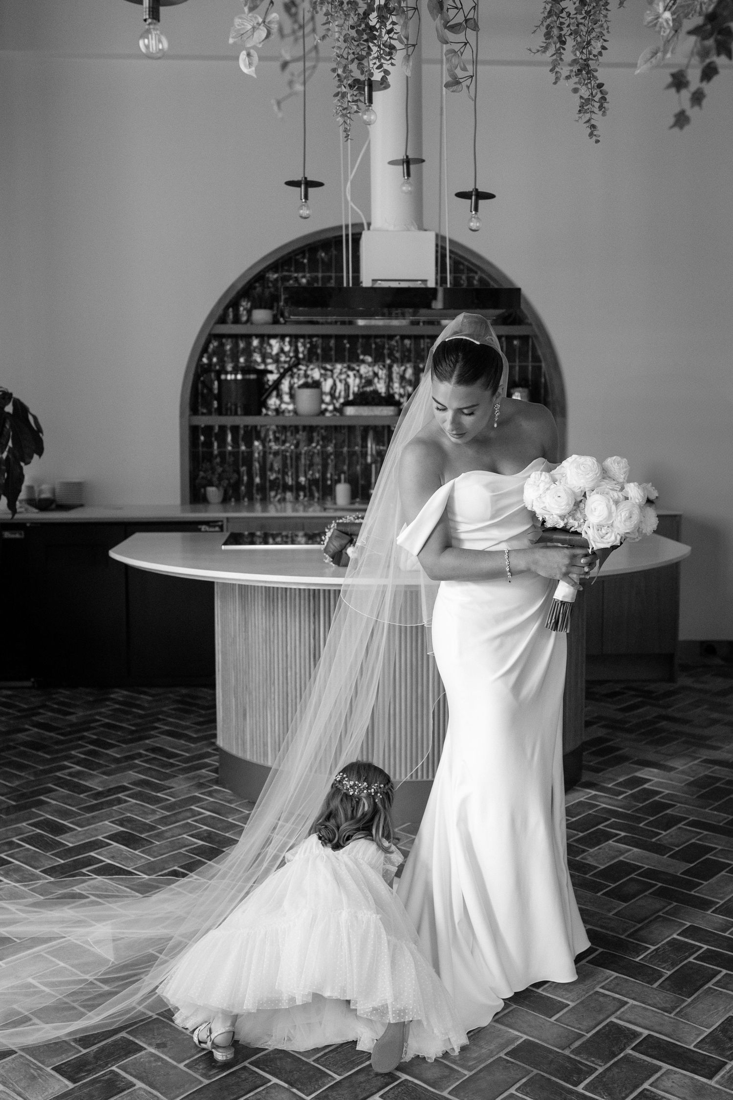 Black and white photo series showing a bride in a flowing white dress and veil getting ready for her wedding ceremony.