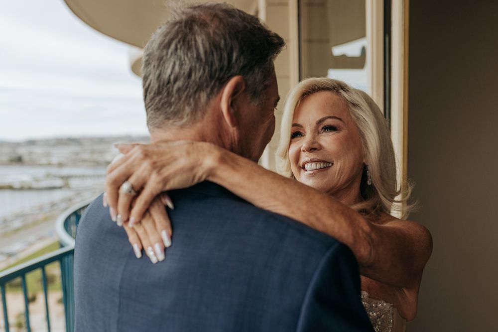 A happy couple shares a tender moment during their wedding celebration at a beachside venue.